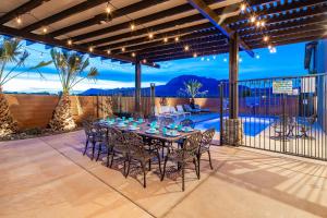 eine Terrasse mit Tisch und Stühlen und einem Pool in der Unterkunft Paradise Village 107 Private Pool, Hot Tub, Pickle-ball, Basketball, Futsal Court, and Game Room in Santa Clara