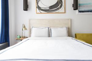 ein Schlafzimmer mit einem großen weißen Bett mit zwei Kissen in der Unterkunft 24-18 New Gramercy Studio W D in Unit Fully Reno in New York