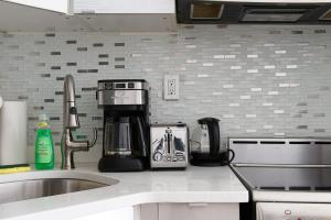 eine Küchentheke mit Kaffeemaschine und Spüle in der Unterkunft 24-18 New Gramercy Studio W D in Unit Fully Reno in New York