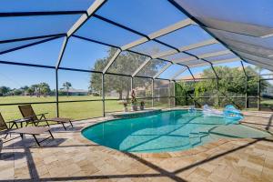 einen Pool unter einem Glasdach mit einer Poolnudel in der Unterkunft Punta Gorda Oasis with Saltwater Pool and Gas Grill! in Punta Gorda