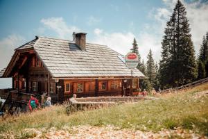 a large wooden building on a hill with people standing around it at Feriennest Ossiachersee in Bodensdorf