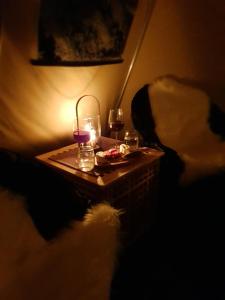 Finnmark Glamping في ألتا: طاولة مع شمعة وكؤوس من النبيذ