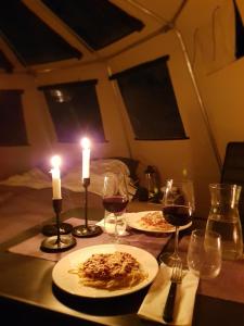 una mesa con dos platos de comida y dos velas en Finnmark Glamping, en Alta