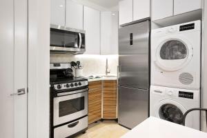 cocina con nevera, lavadora y secadora en 24-6 Gramercy area Newly reno Studio W D in unit, en Nueva York