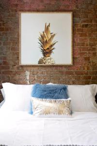 un lit avec une photo d'ananas sur un mur de briques dans l'établissement 24-6 Gramercy area Newly reno Studio W D in unit, à New York