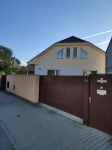 a house with a brown fence and a driveway at XLSuite Apartment Superior in Piešťany