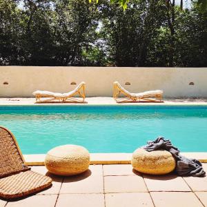 a swimming pool with two chairs and a table and a pool at 1700's Country House with large Private Pool & Gardens in Villeneuve-dʼAveyron
