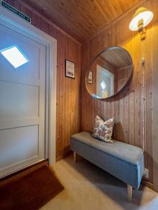 a room with a mirror and a bench in a room at Rostad Retro Rorbuer in Reine