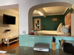 a hotel room with a bed and a kitchen with a counter at Sweetest Apartments in Cape Town