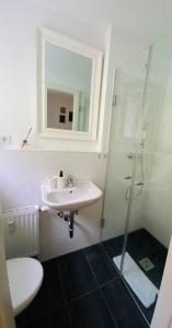 a white bathroom with a sink and a shower at Ferienwohnung „Marina“ im Schwarzwald in Lörrach