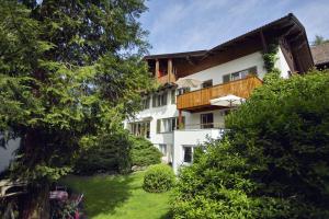 a white building with a balcony and a yard at Ferienwohnung Seidelbast in Füssen