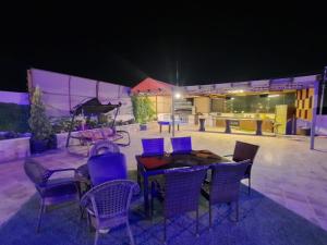 a group of chairs and tables on a patio at night at The Oaks in Madaba