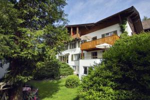 een wit gebouw met een balkon en een tuin bij Ferienwohnung Edelweiss in Füssen