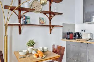 una cucina con tavolo in legno e orologio sul muro di Nice apartment in the 6th arr of Paris - Welkeys a Parigi
