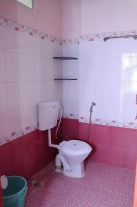 a bathroom with a toilet in a pink bathroom at ROYAL GREEN AIRPORT TRANSIT ACCOMMODATION in Chennai