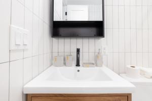 W białej łazience znajduje się umywalka i lustro. w obiekcie 323-2 Specious 2BR Williamsburg w mieście Brooklyn