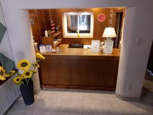 a reception desk in a hotel room with flowers at Hotel Cristal in Mendoza