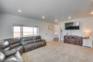 a living room with a leather couch and a flat screen tv at Garden City Retreat with Access to Bear Lake! in Garden City