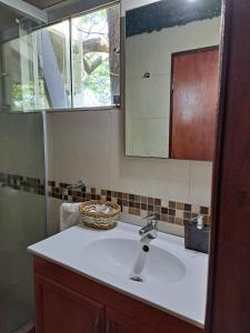 a bathroom with a sink and a mirror at Mini casa en el mirador San Bernardino. Guarania in San Bernardino