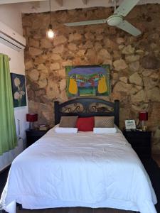 a bedroom with a large bed in a stone wall at Mini casa en el mirador San Bernardino. Guarania in San Bernardino