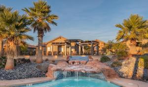 a swimming pool in a yard with palm trees at Paradise Village at Zion 28 Private Hot Tub, Outdoor firepit, and Community Pool in Santa Clara