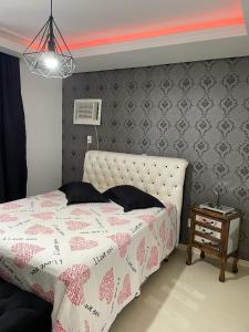 a bedroom with a bed with a pink and white comforter at Casa completa com piscina no Paraíso do Brasil in Governador Celso Ramos +38 photos
