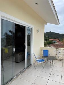a patio with a table and a blue chair at Casa completa com piscina no Paraíso do Brasil in Governador Celso Ramos