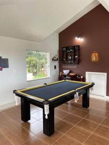 a pool table in a living room with at Casa completa com piscina no Paraíso do Brasil in Governador Celso Ramos