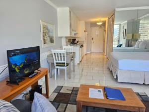 een woonkamer met een bed en een tv in een kamer bij Ilikai Marina 987 City View Studio in Honolulu