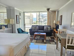 een slaapkamer met een bed en een woonkamer met een bank bij Ilikai Marina 987 City View Studio in Honolulu