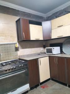 a kitchen with wooden cabinets and a stove top oven at شقة ايجار مفروش 4 نوم 3 حمام 4 ريسيبشن in Cairo