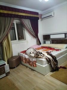1 dormitorio con cama y ventana en شقة ايجار مفروش 4 نوم 3 حمام 4 ريسيبشن, en El Cairo