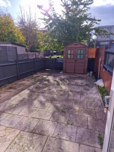 a patio with a small shed in a backyard at KO 3 bed house in Kent