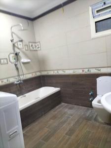a bathroom with a tub and a toilet and a sink at شقة ايجار مفروش 4 نوم 3 حمام 4 ريسيبشن in Cairo