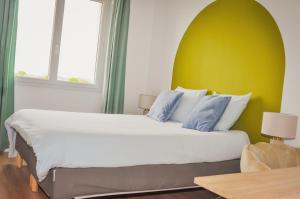 a bedroom with a large bed with a yellow wall at Les Chambres de Troyes - Parking Free Fibre Netflix in Troyes