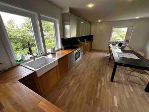 a large kitchen with a sink and a table at Villa Livslust Trollbäcken uthyrning pågår in Tyresö