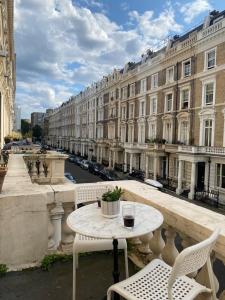a table and chairs on a balcony with a building at Flat w/ terrace in Notting Hill in London