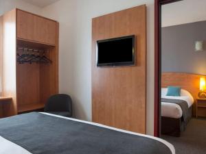 a hotel room with a bed and a flat screen tv at The Originals City, Plume Hôtel, Bressuire in Bressuire +15 photos