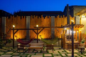 un patio con sillas y hamacas por la noche en wanderholic en Tʼelavi