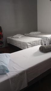 two twin beds in a room with white walls at Casa no Centro de São Lourenço in São Lourenço