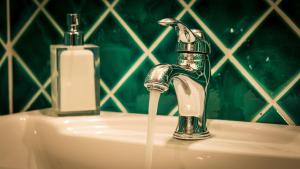 a bathroom sink with water running from a faucet at Palazzo Dessy in Cagliari +64 photos