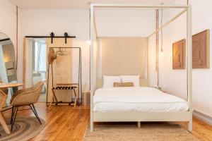 ein Schlafzimmer mit einem Himmelbett und einem Tisch in der Unterkunft Amália Boutique Suites & Studios - by @ rita´s place in Faro