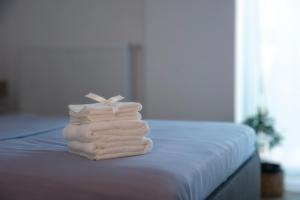 una pila de toallas sentadas encima de una cama en Oasis Studio, en Bucarest