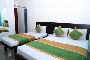 two beds sitting next to each other in a room at Royal Green - Airport Stay in Chennai