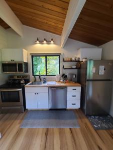 a kitchen with white cabinets and stainless steel appliances at A Restful Studio Near a Creek and Forest - Pet Friendly in Roseburg