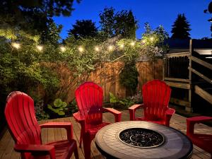 un patio con sillas rojas, una mesa y luces en Modern Beach House long stay discounts, en Sarnia