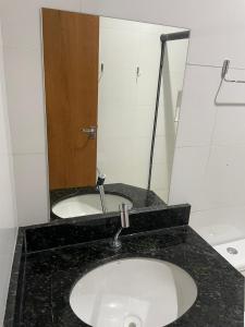 a bathroom counter with a sink and a mirror at Unidades mobiliadas em condomínio in Lucas do Rio Verde