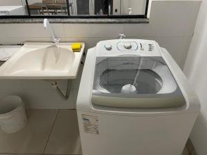 een wasmachine naast een wastafel in een badkamer bij Unidades mobiliadas em condomínio in Lucas do Rio Verde