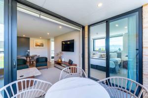 Zimmer mit Glasschiebetüren und einem Schlafzimmer in der Unterkunft Majestic Mountain-View Retreat in Wanaka