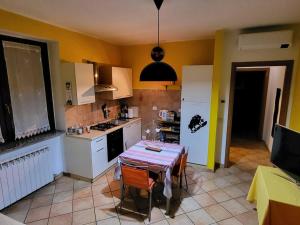 a kitchen with a table and a kitchen with yellow walls at Home Sweet Home in Bareggio